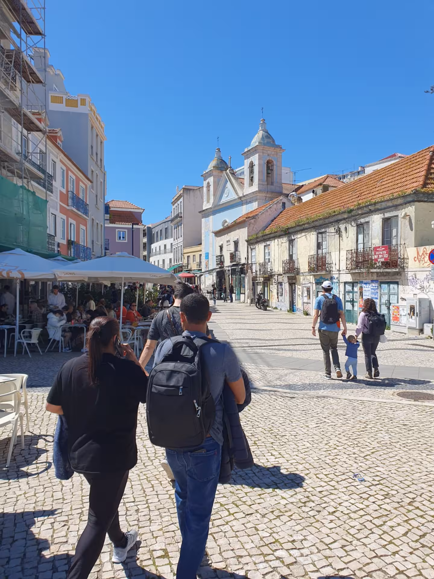 Charming Almada street scene with colorful buildings and church, capturing local culture near Lisbon.