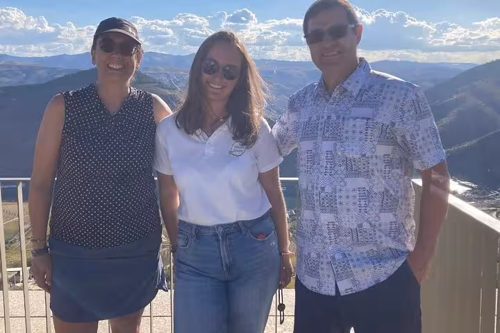 Tour guide and guests smiling at Alto Douro Wine Region scenic overlook with stunning mountain valley views