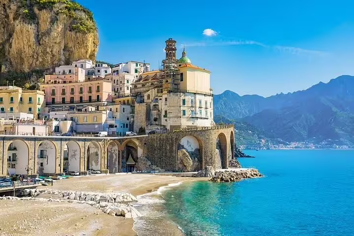 Sunny beach and historic cliffside village of Atrani along turquoise sea on a private full day Amalfi Coast tour