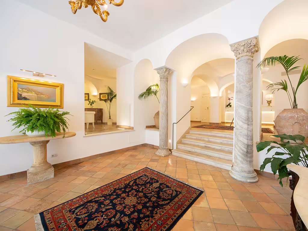 Elegant Amalfi Coast boutique hotel lobby with arches, marble columns and classic décor for a romantic getaway