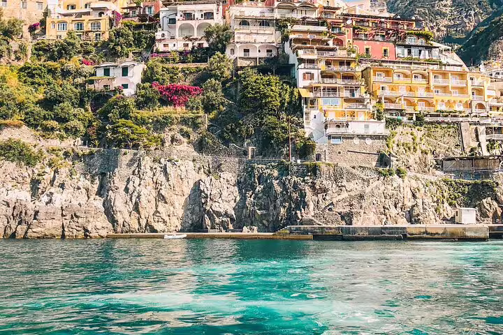 Colorful cliffside buildings overlooking turquoise waters of the Amalfi Coast, Italy
