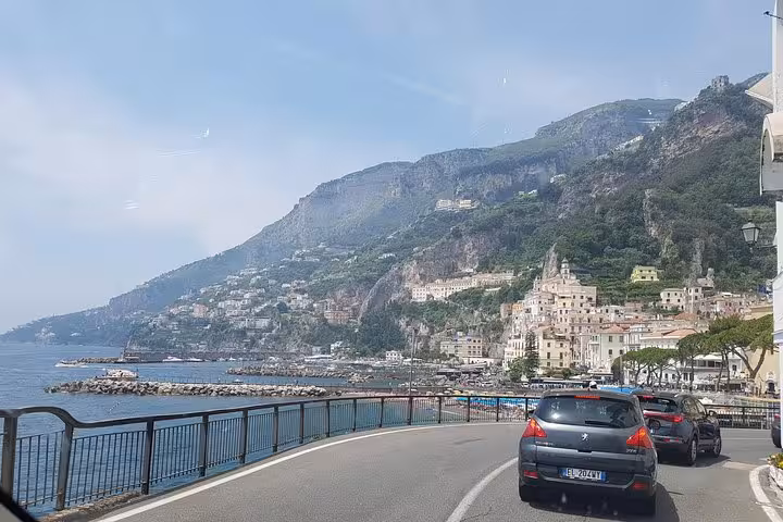Coastal road near Amalfi town with sea views and hillside villages, classic Amalfi Coast day trip from Rome
