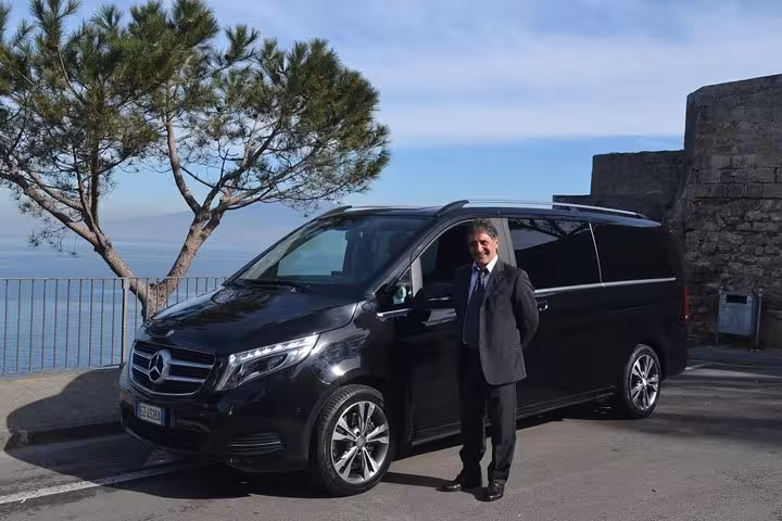 Luxurious minivan ready for a full-day Amalfi Coast tour from Sorrento with scenic coastal views.