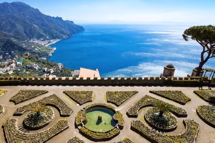 Breathtaking view of Amalfi Coast from a garden terrace, showcasing azure sea and stunning coastal landscapes.