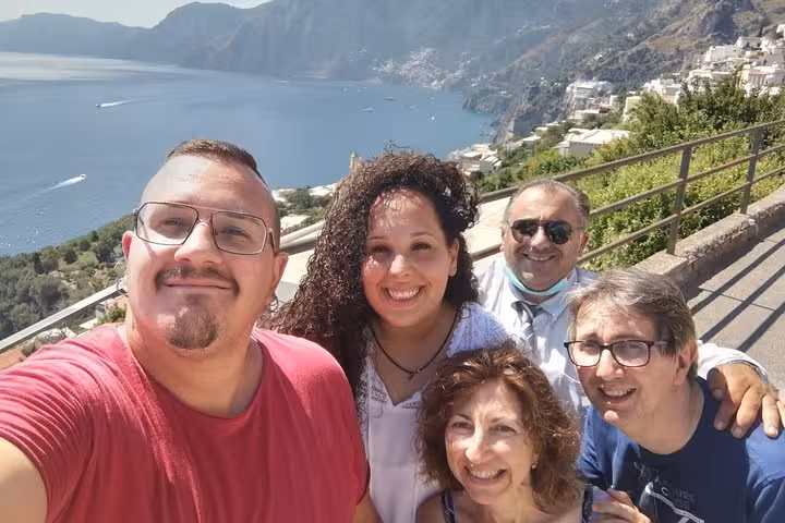 Smiling group enjoying stunning Amalfi Coast views during a full-day private tour from Positano.