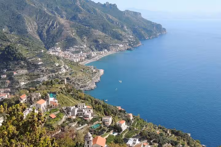 Scenic view of the Amalfi Coast with vibrant blue waters and lush hills, ideal for a private transfer to Rome.
