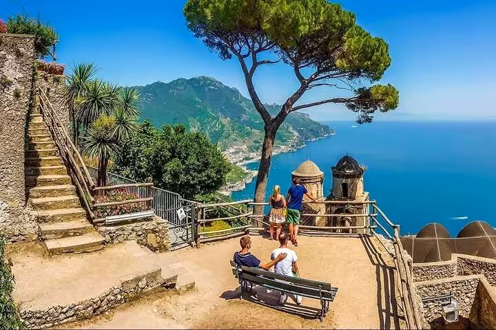Tourists enjoying panoramic views of the Amalfi Coast from a scenic spot in Ravello on a sunny day.