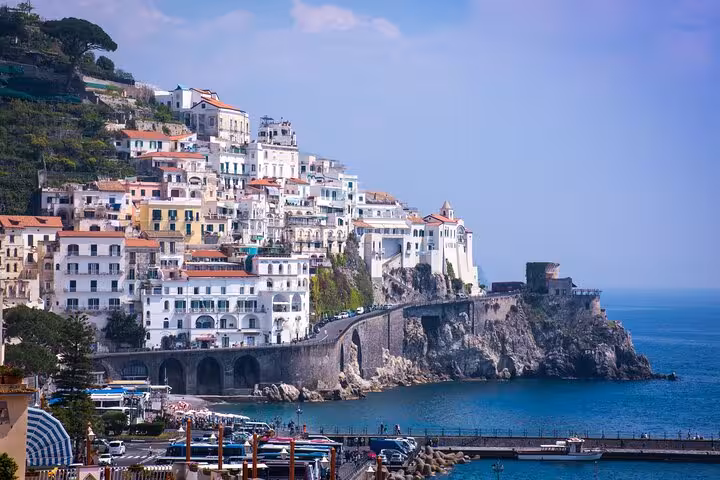 Charming seaside village of Amalfi with whitewashed buildings perched on cliffs above the azure Mediterranean Sea.