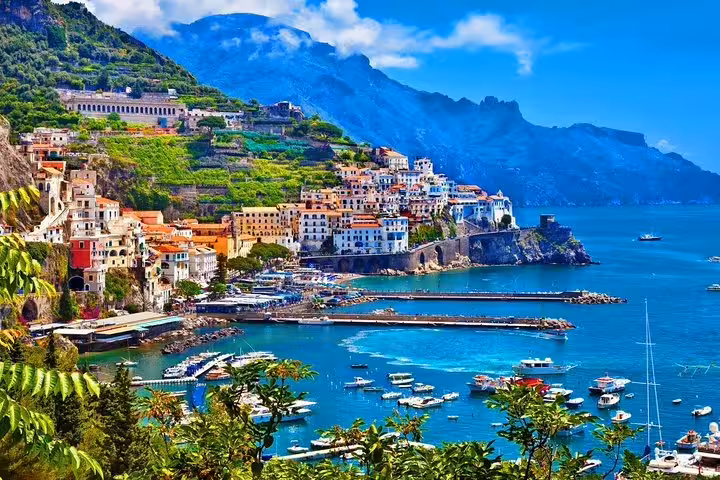 Amalfi Coast tour from Naples with panoramic Amalfi town, terraced cliffs, and boats in turquoise sea
