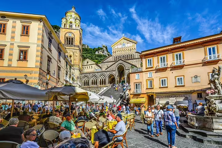 Amalfi Cathedral and lively piazza cafés, travelers on VIP small-group Amalfi Coast tour walking in town