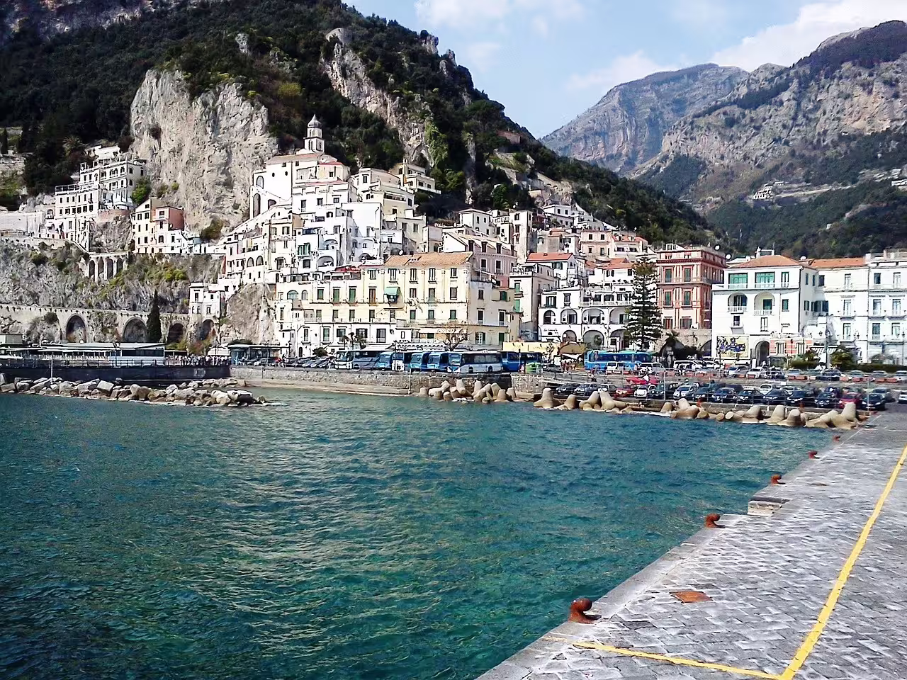 Colorful Amalfi town and harbor with turquoise sea and mountains, departure point for Li Galli and Capri boat trips