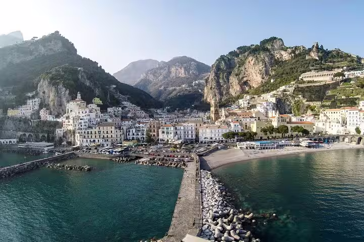 Panoramic view of Amalfi town and marina with pastel houses, cliffs and turquoise sea on a Ravello Amalfi Positano day tour