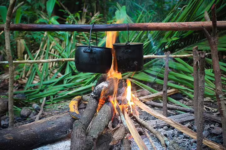 Cooking pots over open campfire in Amazon jungle survival adventure tour from Manaus Brazil