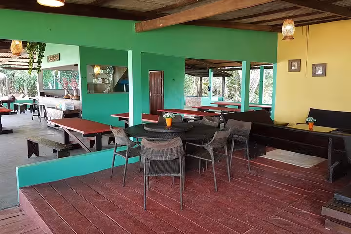 Open-air Amazon jungle lodge dining area with tables and chairs, ideal base on a 5-day Amazon jungle adventure tour