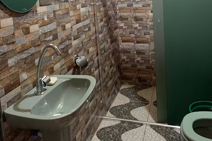 Modern bathroom facilities at Amazon Mamori Lodge featuring stone walls and eco-friendly designs.