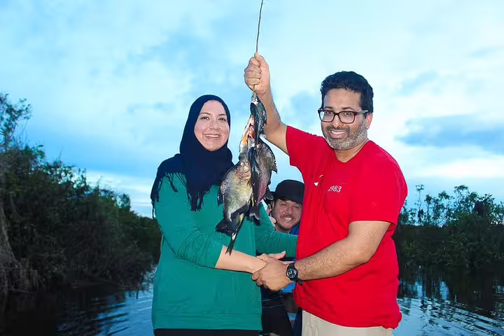 Tourists proudly display their catch of the day during a piranha fishing adventure in the heart of the Amazon rainforest.