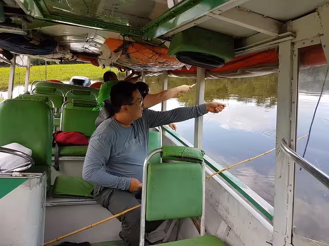 Guests fishing from a riverboat on the Solimões River, part of the Amazon piranha fishing night tour
