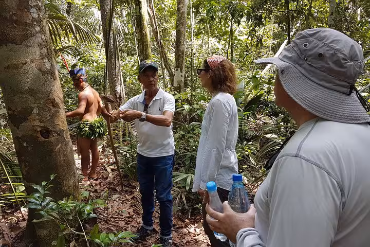Local guide briefs trekkers during an Amazon rainforest 4-hour hike, with water bottles and jungle gear