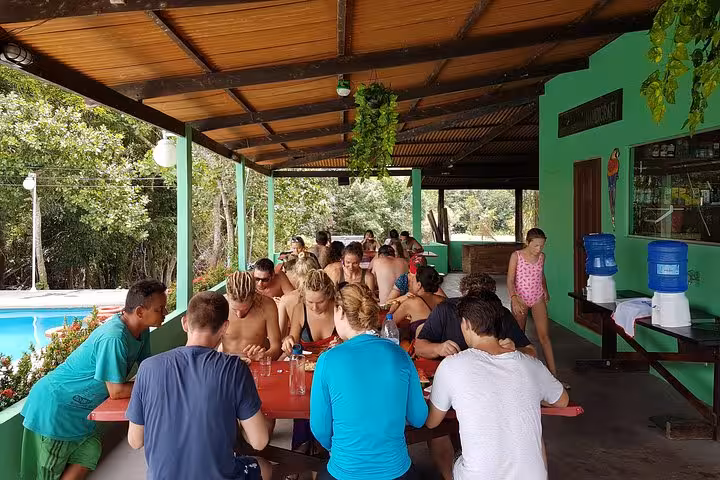 Group lunch at an Amazon rainforest lodge near the pool, social dining on a 5-day Amazon jungle adventure tour