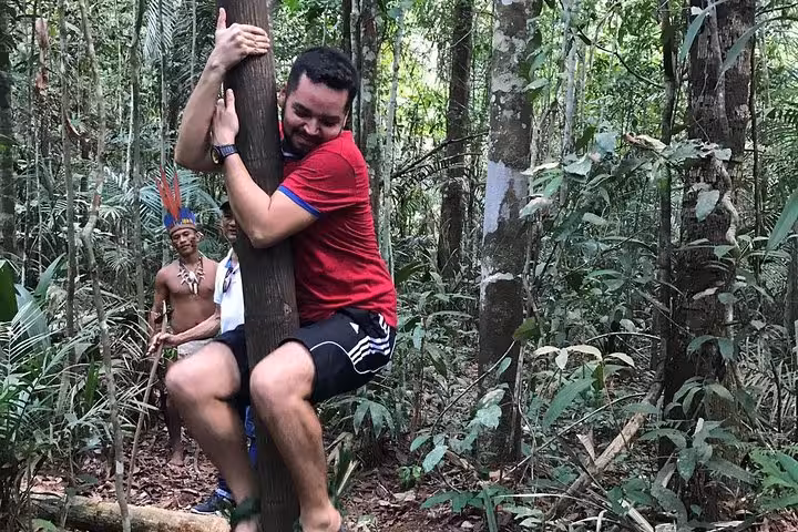 Traveler hugging a tree on an Amazon Forest Tour 4-hour trekking, with jungle guide and rainforest backdrop