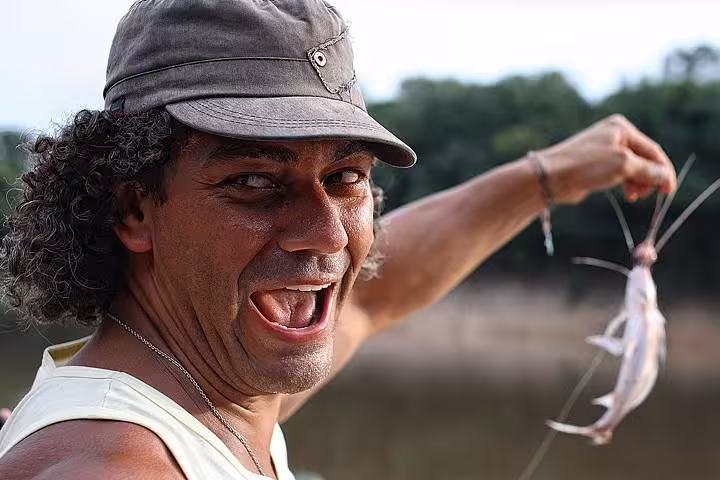 Guide holding a freshly caught catfish during an Amazon Negro River half-day expedition tour near Manaus