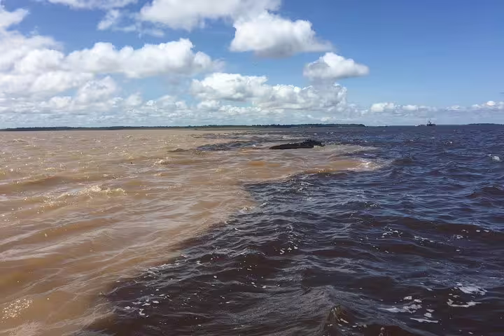 Confluence of brown and blue waters at the Amazon River, highlighting the unique natural phenomenon of meeting waters.