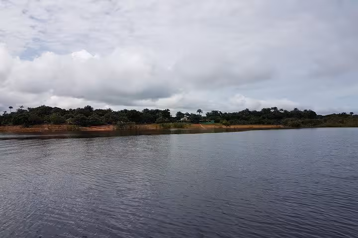Calm Amazon River lagoon view on a 3-day Amazon jungle adventure tour with rainforest shoreline and clouds