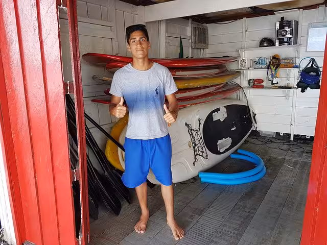 SUP tour guide at an Amazon River paddleboard base, with boards and gear ready for a stand up paddling tour
