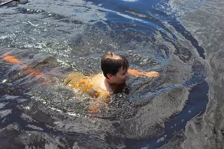 Person swimming in the refreshing waters of the Amazon River near Mamori Lodge, enjoying a thrilling jungle experience.