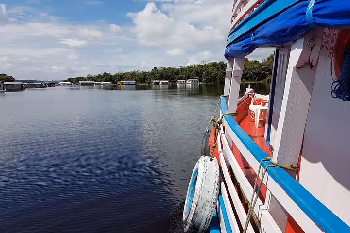 Side view of Amazon riverboat passing floating houses on Manaus to Tabatinga route, private cabin journey