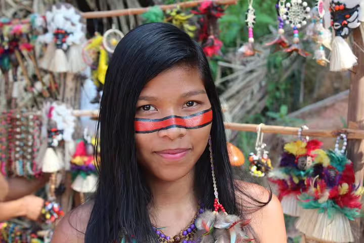 Local artisan with traditional face paint and beaded jewelry, showcasing Amazonian culture near Tapiri Rio Negro Lodge.