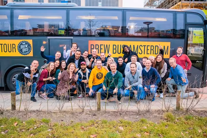 Large group posing by Brew Bus Amsterdam coach before craft beer brewery tour with tastings