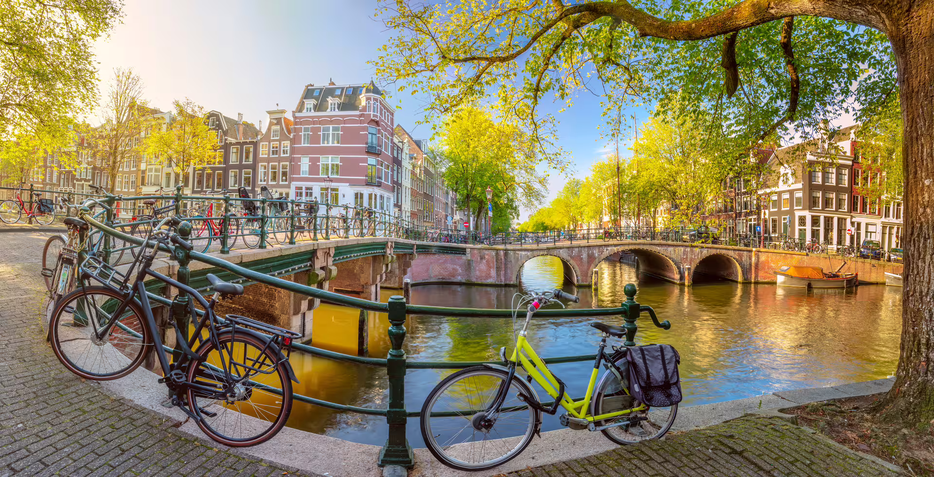 Amsterdam canal bridge with bikes and historic houses, scenic highlight on a 1-day walking tour audioguide