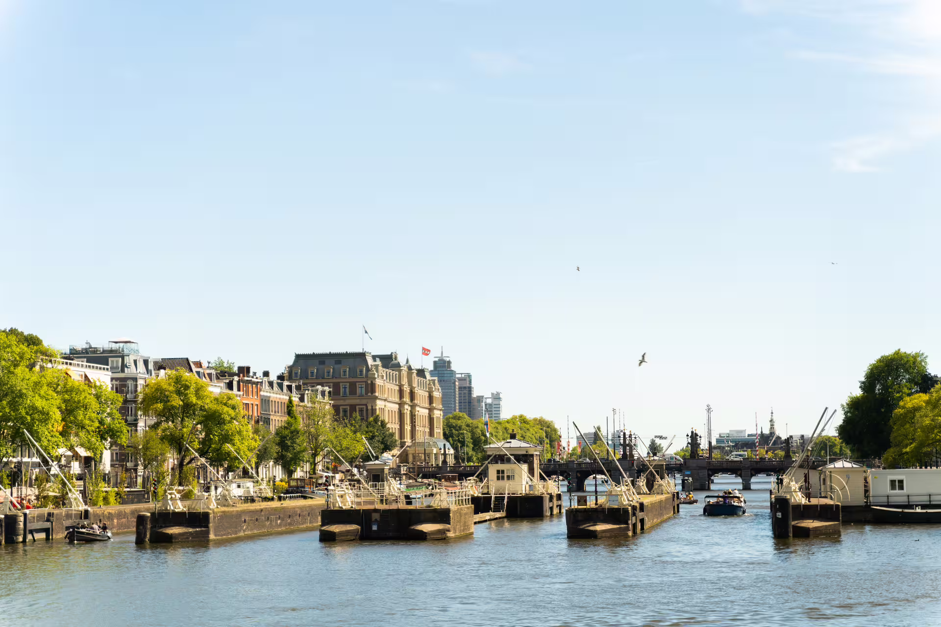 Scenic view of Amsterdam canal with historic architecture and boats, ideal for countryside bike tour and canal cruise experience.