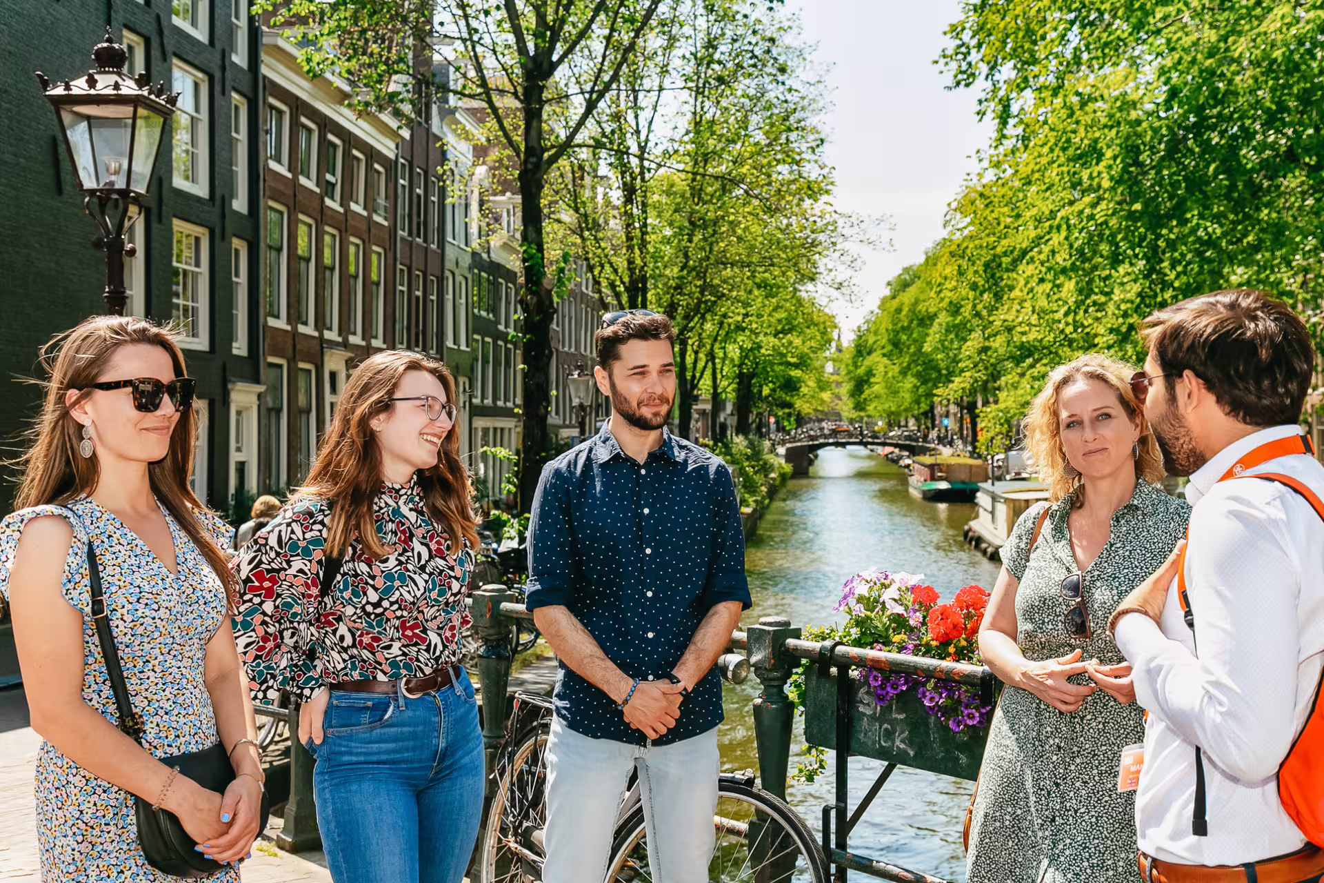 Tourists enjoy a guided walking tour along Amsterdam's picturesque canals, exploring the city's rich historical secrets.