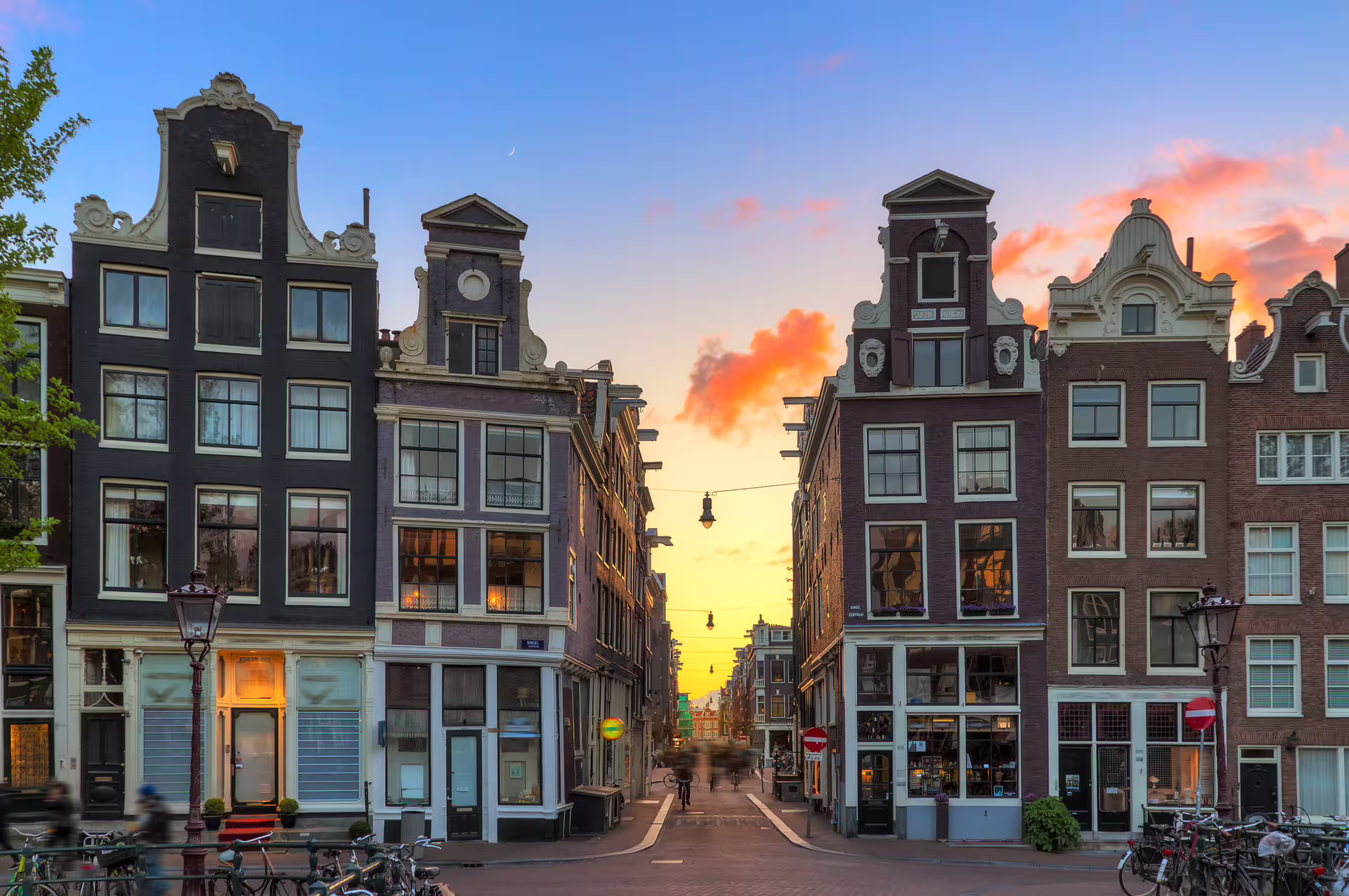 Sunset view of Amsterdam canal houses and street, perfect for Amsterdam in 1 day walking tour audioguide