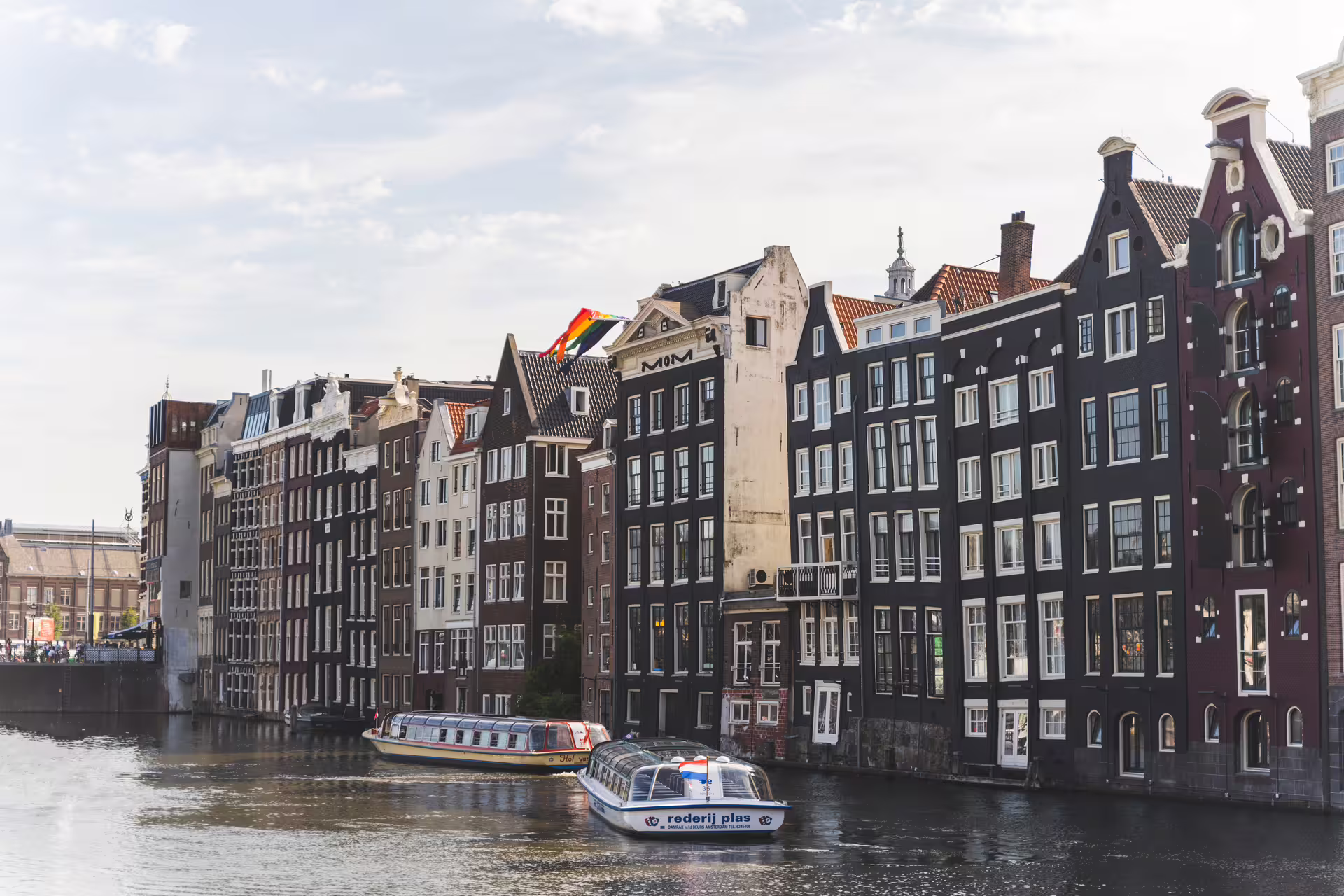 Scenic view of Amsterdam's iconic canal houses and boats, ideal for exploring during a private walking tour of the city.