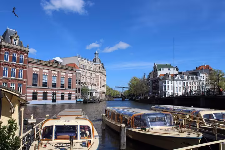 Canal-side architecture and moored boats in central Amsterdam, perfect backdrop for a private local walking tour