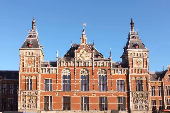 Amsterdam Central Station facade in sunlight, iconic highlight on a private city walking experience with a local