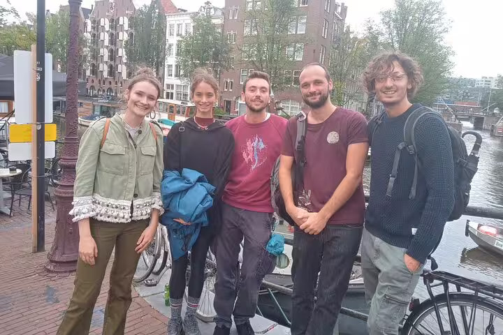Five friends posing together on an Amsterdam canal bridge during a self-guided walking tour