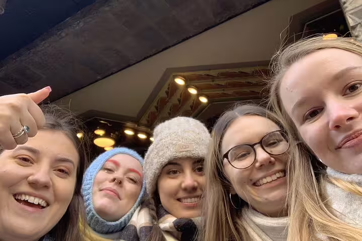 Five smiling women taking a selfie together on a walking tour in Amsterdam
