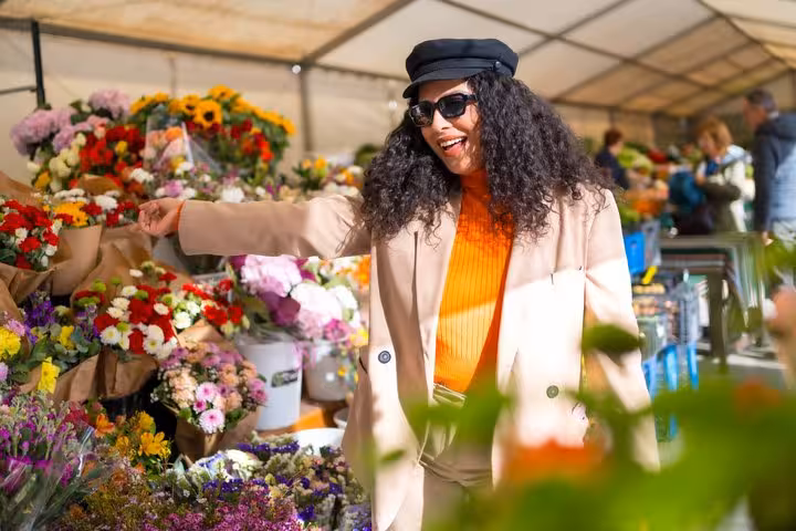 Woman shopping for colorful flowers at Amsterdam Flower Market stall