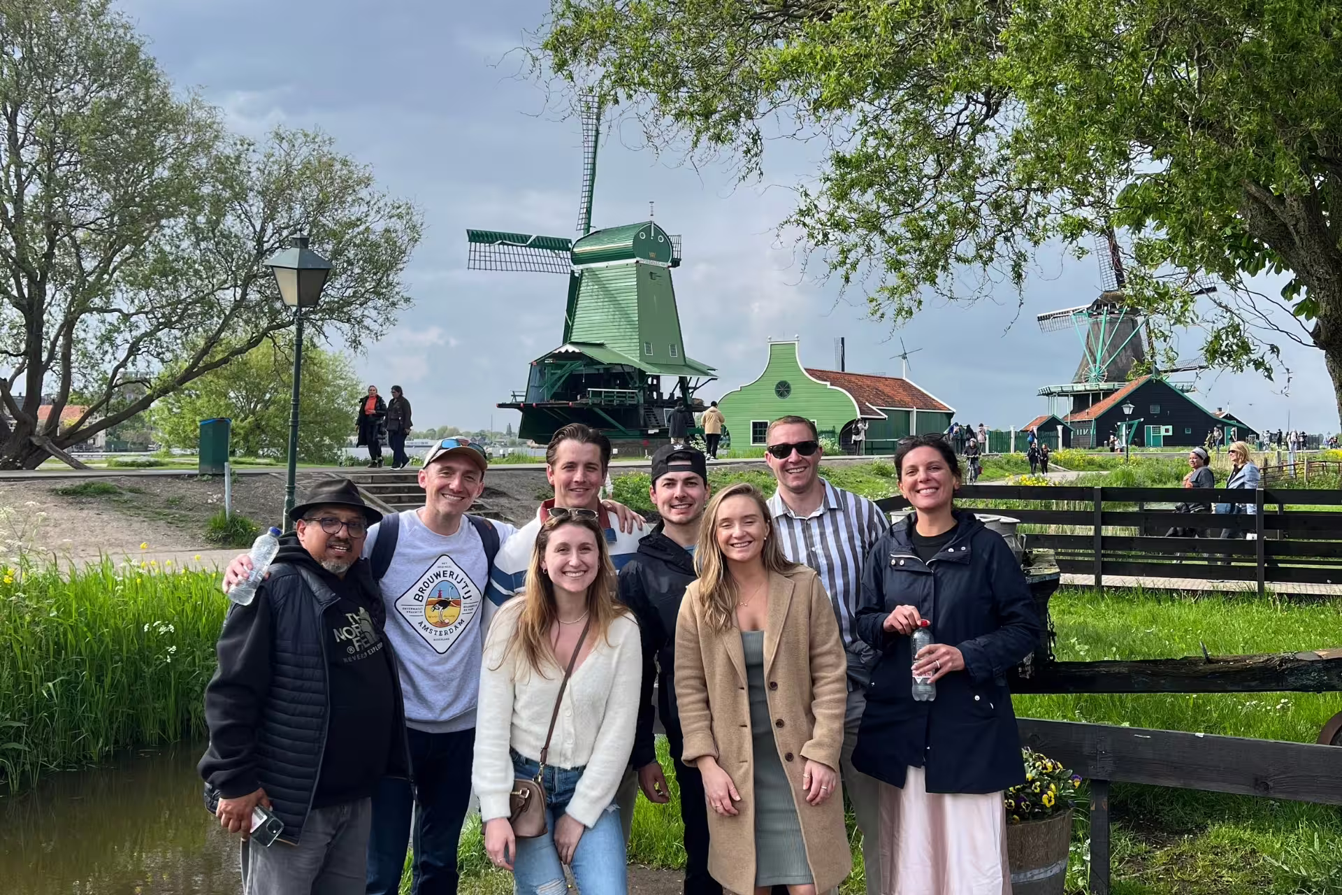 Tour group at Zaanse Schans windmills on Amsterdam day trip to Giethoorn with canal cruise experience