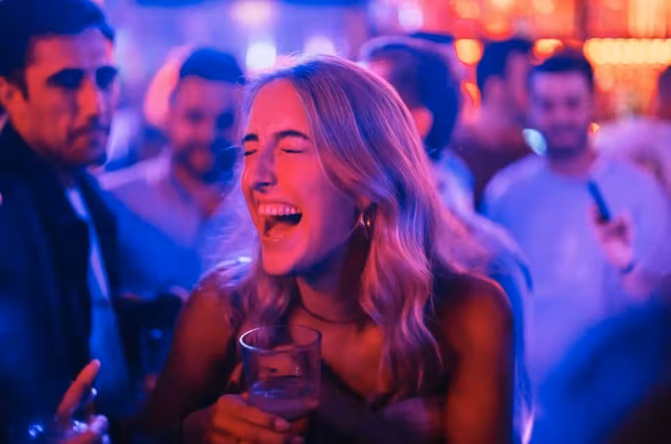 Partygoer laughing with a drink in Amsterdam nightclub on Halloween pub crawl with VIP club entry included
