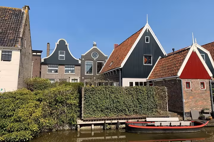 Canal-side traditional Dutch houses and boat in a quiet village, Hidden Gems tour from Amsterdam