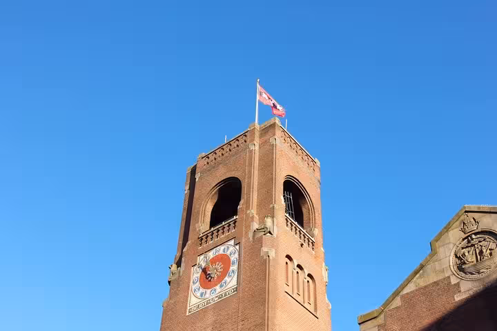 Historic Amsterdam tower with clock and Dutch flag, ideal landmark stop on a customized private walking tour