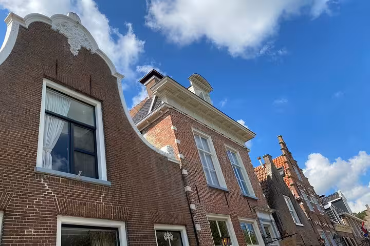 Historic Dutch gabled brick houses under blue sky, scenic stop on a private tour from Amsterdam to the North