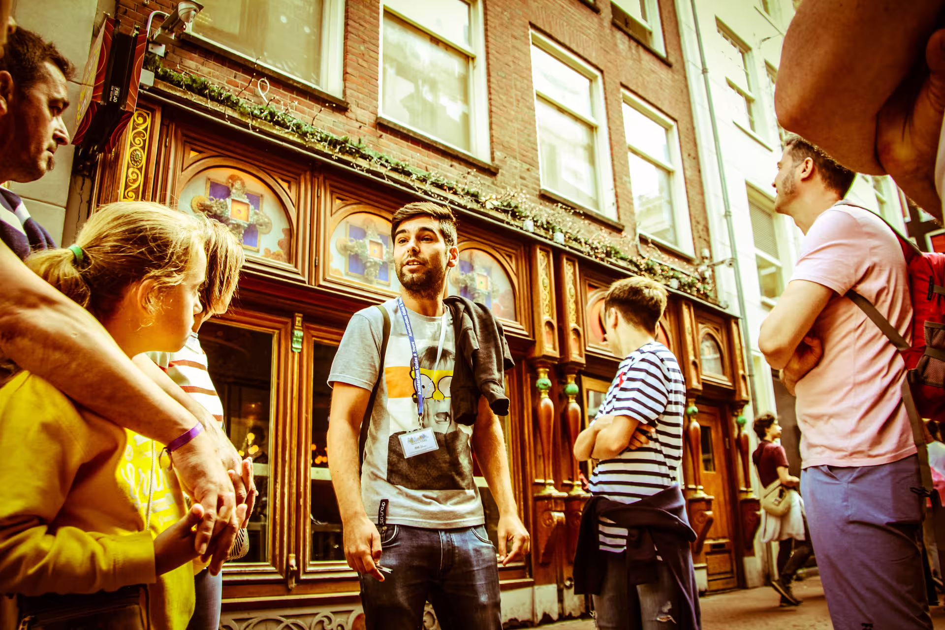 Tour guide leading a group through Amsterdam's historic streets on a private walking tour, showcasing charming architecture.