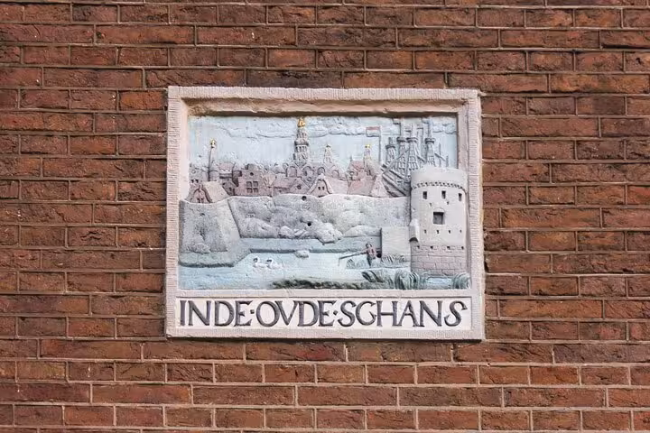 Inde Oude Schans historic wall plaque on brick facade, detail seen on a private Amsterdam city walk with local