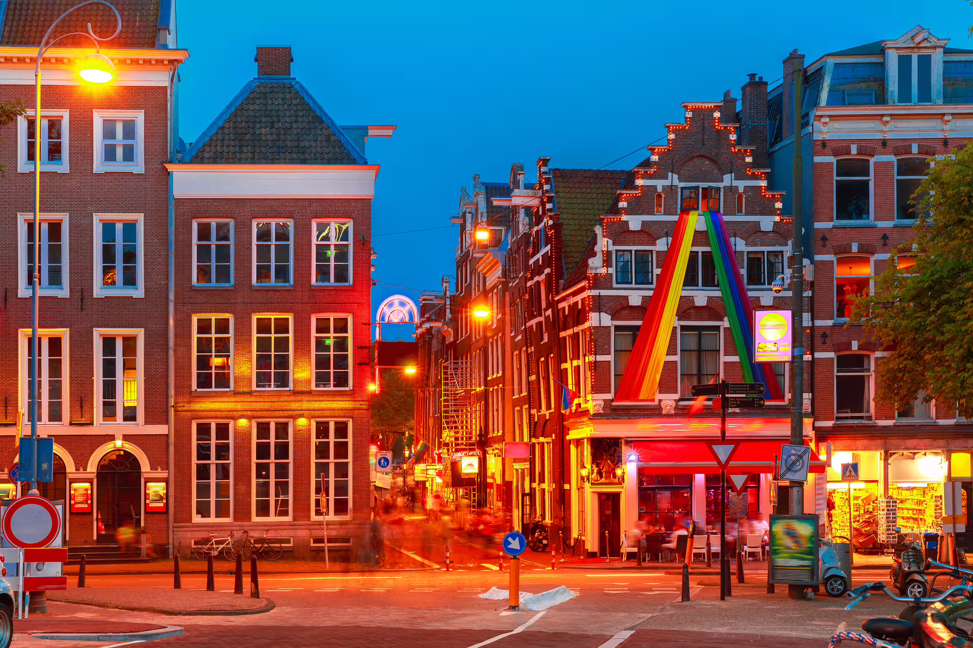 Evening street scene near Amsterdam Red Light District with canal houses, perfect for 1-day audioguide walk